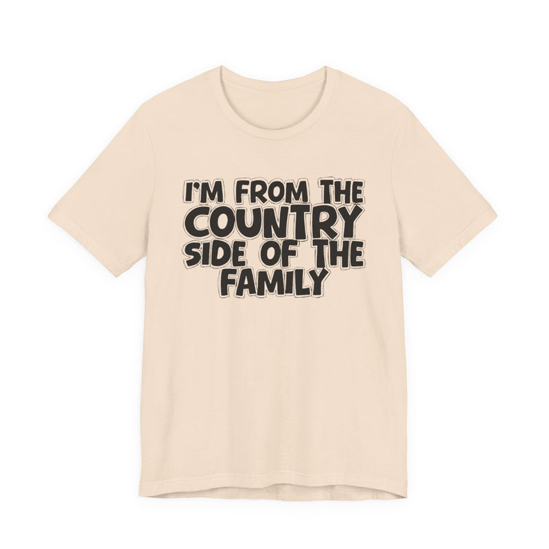 Soft Cream t-shirt with white outlined bubble lettering reading 'I'M FROM THE COUNTRY SIDE OF THE FAMILY', front flat-lay view.