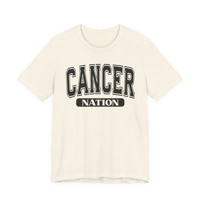 Natural cream t-shirt with black arched CANCER collegiate lettering over a white NATION pill badge, front flat-lay view.