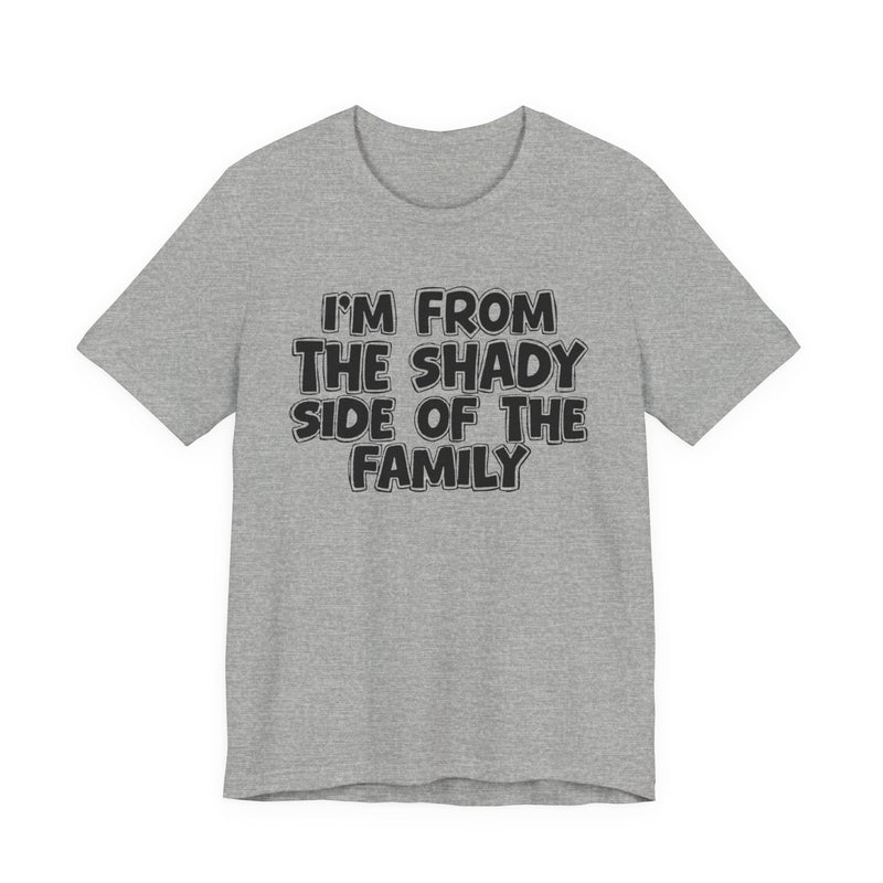 light t-shirt with ‘I’M FROM THE SHADY SIDE OF THE FAMILY’ statement text in bold outline lettering, front flat-lay view.