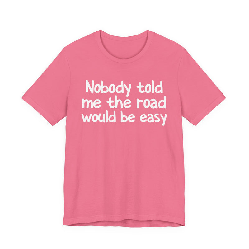 T-Shirt with text design reading “NOBODY TOLD ME THE ROAD WOULD BE EASY”, front view