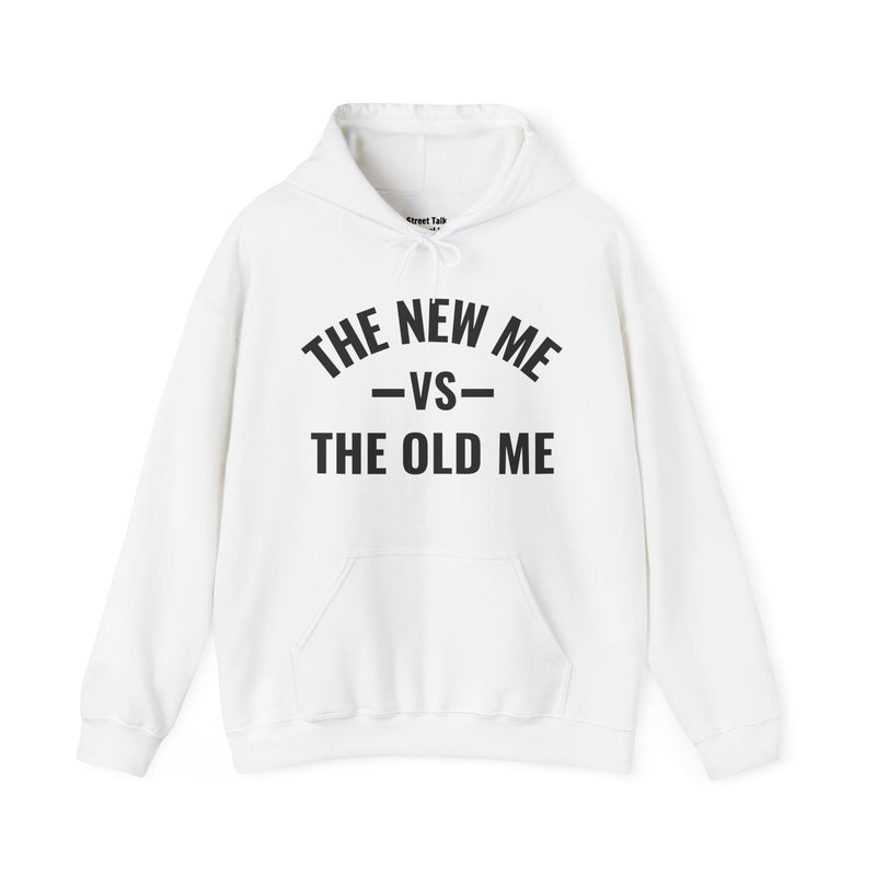 White hoodie with dark bold versus-style lettering reading THE NEW ME VS THE OLD ME, front flat-lay view.