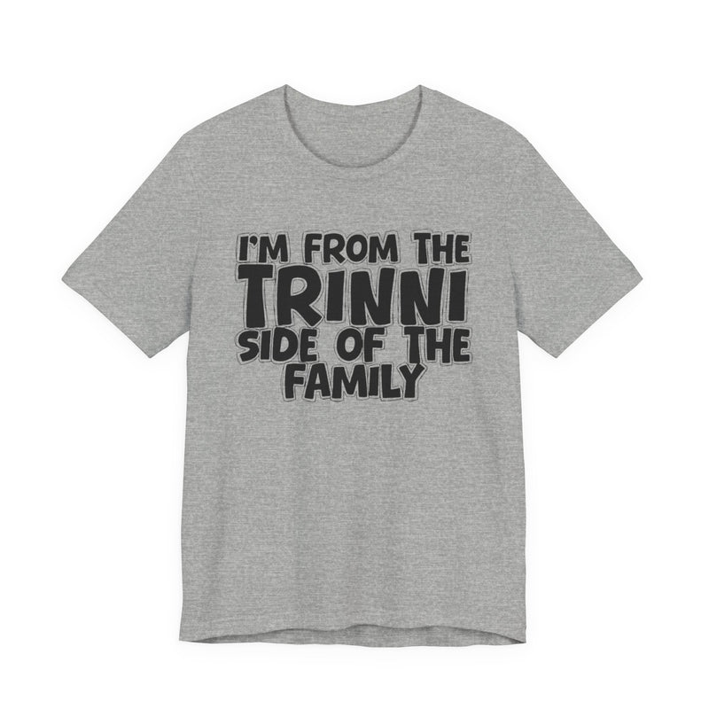 Athletic Heather t-shirt with 'I'M FROM THE TRINNI SIDE OF THE FAMILY' in black hand-drawn bubble lettering on the chest, front flat-lay mockup view.