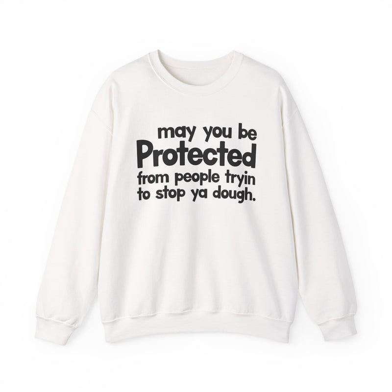 May You Be Protected From People Tryin To Stop Ya Dough — Sweatshirt fabric detail close-up: MAY YOU BE PROTECTED FROM PEOPLE TRYIN TO STOP YA DOUGH in bold statement lettering. Street Talk Designs protection statement apparel.