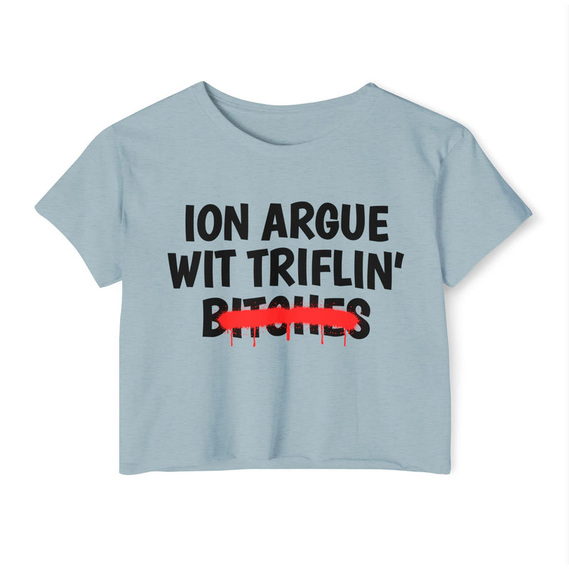 Stonewash Denim crop top with black printed statement graphic, front view: 'ION ARGUE WIT TRIFLIN'' in bold all-caps letters, 'BITCHES' crossed out in a red graffiti strike with paint drips.