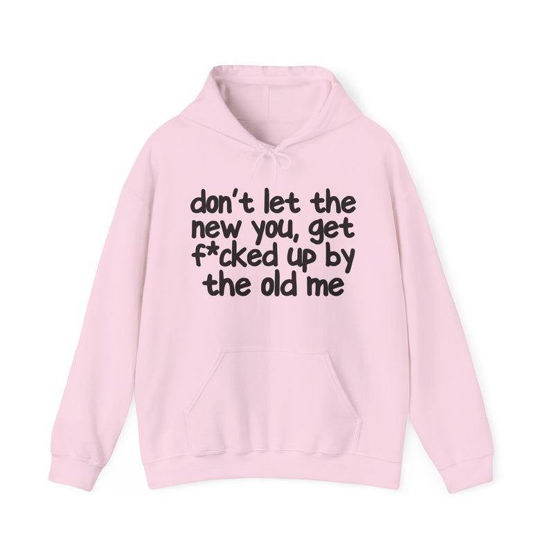 White hoodie with dark bold confrontation lettering reading DON'T LET THE NEW YOU, GET FUCK'D UP BY THE OLD ME, front flat-lay view.