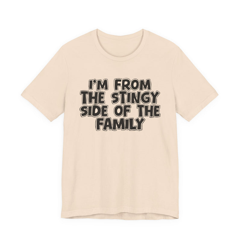 Soft Cream t-shirt, printed with the "I'M FROM THE STINGY SIDE OF THE FAMILY" statement in bold outlined bubble lettering, front flat-lay view.