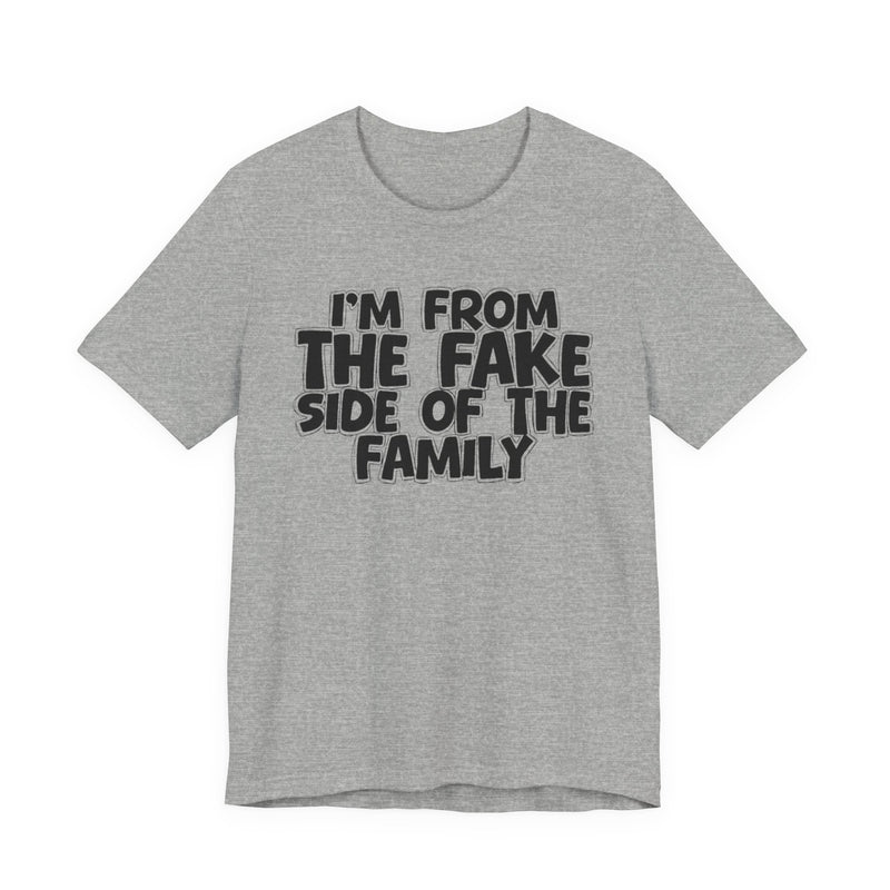 Athletic Heather t-shirt with "I'M FROM THE FAKE SIDE OF THE FAMILY" in bold black outlined bubble lettering, front flat-lay view