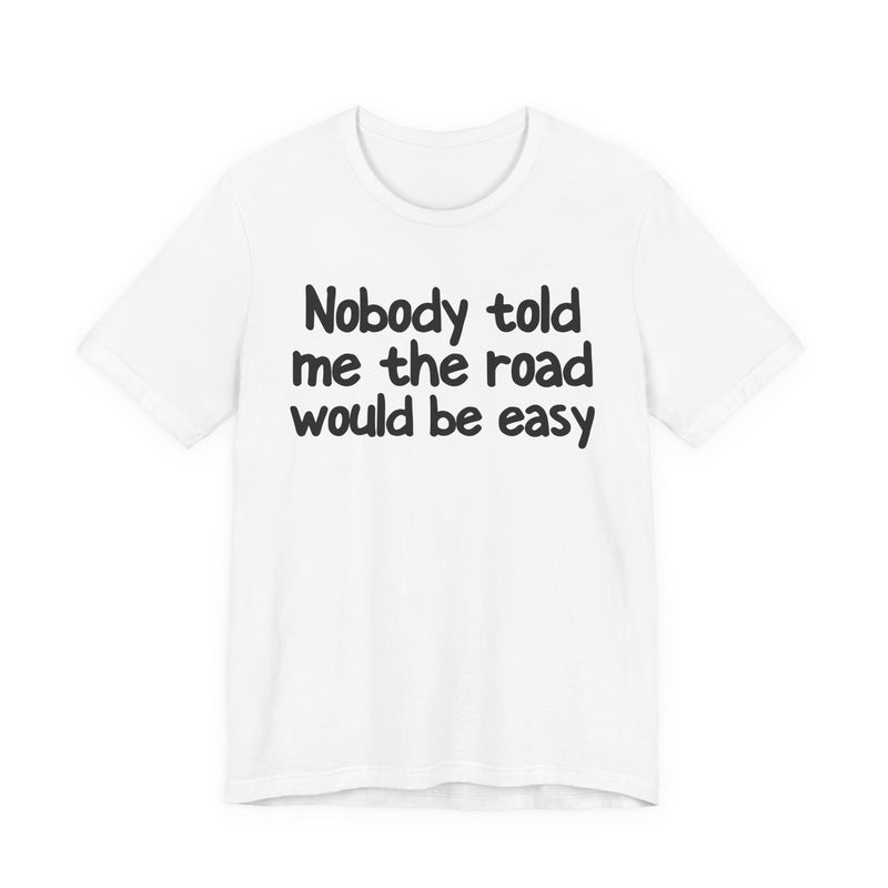 T-Shirt with text design reading “NOBODY TOLD ME THE ROAD WOULD BE EASY”, front view