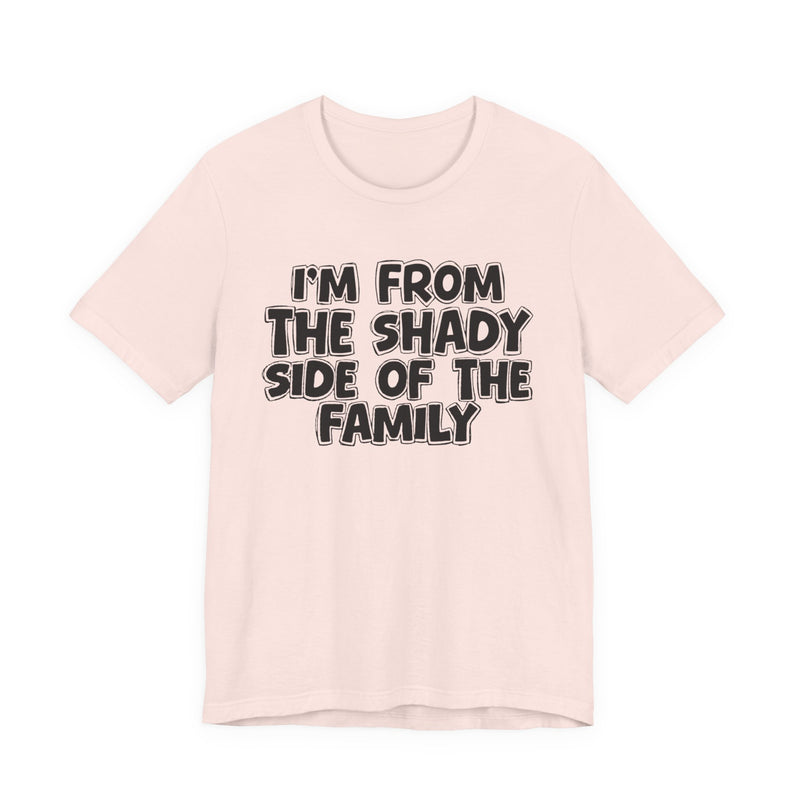 light t-shirt with ‘I’M FROM THE SHADY SIDE OF THE FAMILY’ statement text in bold outline lettering, front flat-lay view.