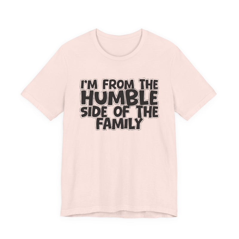light t-shirt with ‘I’M FROM THE HUMBLE SIDE OF THE FAMILY’ statement text in bold outline lettering, front flat-lay view.