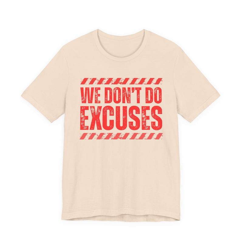 Light pink t-shirt with red bubble lettering reading WE DON'T DO EXCUSES, front view.