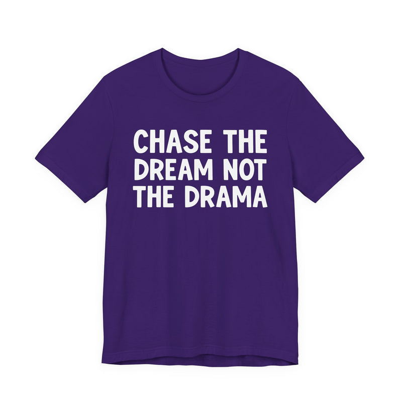 Purple t-shirt with white bold statement lettering reading CHASE THE DREAM NOT THE DRAMA, front flat-lay view.