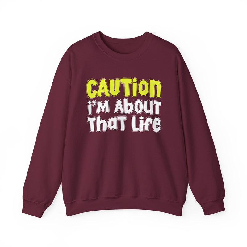Sweatshirt in Maroon with lettering reading "CAUTION I'M ABOUT THAT LIFE", front view.