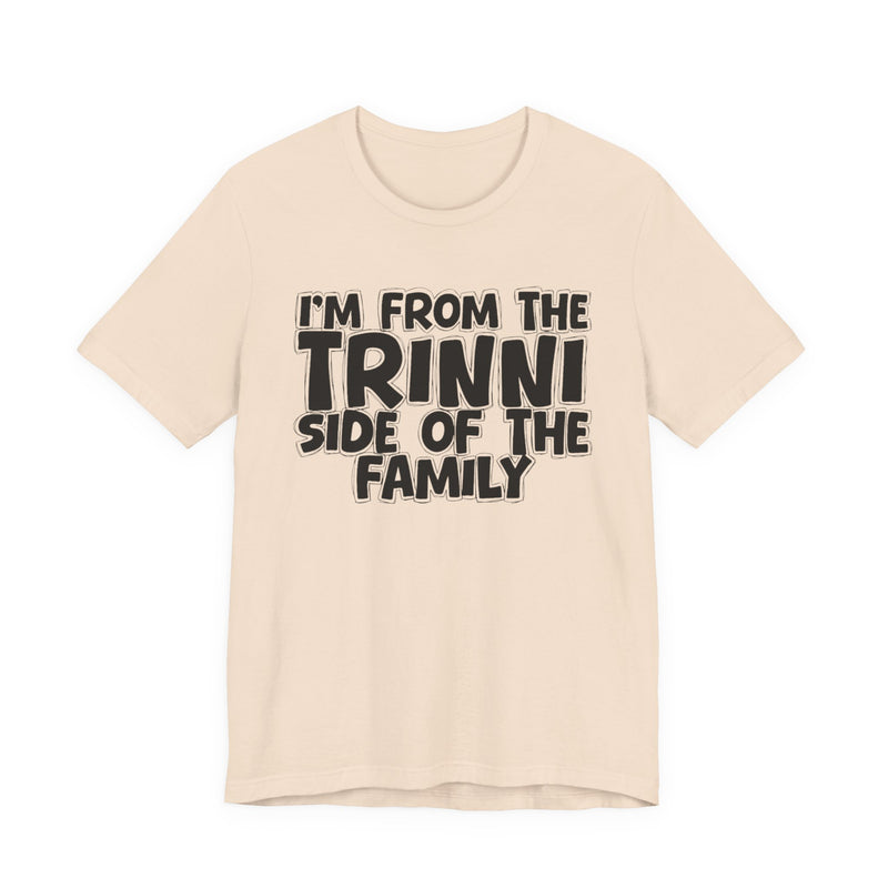 Natural t-shirt with 'I'M FROM THE TRINNI SIDE OF THE FAMILY' in black hand-drawn bubble lettering on the chest, front flat-lay mockup view.