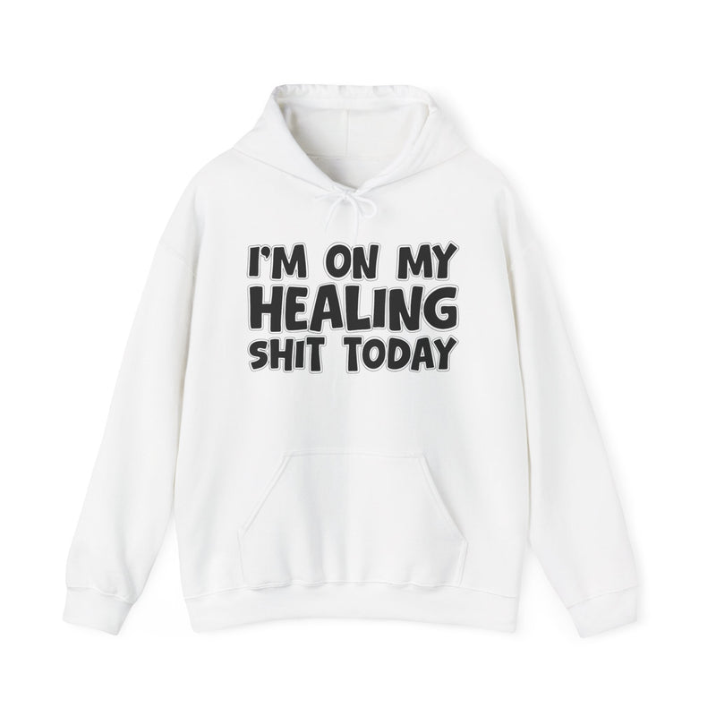 White hoodie with white bubble lettering reading "I'M ON MY HEALING SHIT TODAY", front flat-lay view.