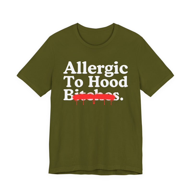 Olive T-Shirt with serif lettering reading Allergic To Hood Bitches, crossed by a red dripping strikethrough, front flat-lay view.