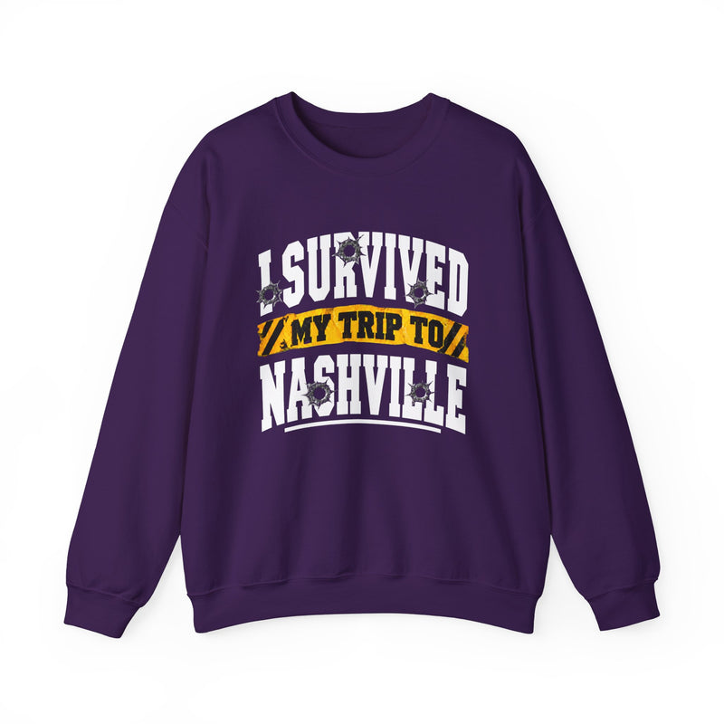 Purple sweatshirt with white block lettering reading I SURVIVED MY TRIP TO NASHVILLE, with bullet-hole accents and a yellow caution-tape banner, front flat-lay view.