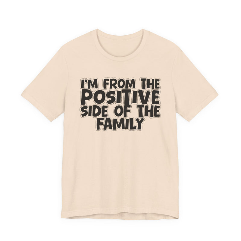 Soft Cream t-shirt with white outlined bubble lettering reading 'I'M FROM THE POSITIVE SIDE OF THE FAMILY', front flat-lay view.