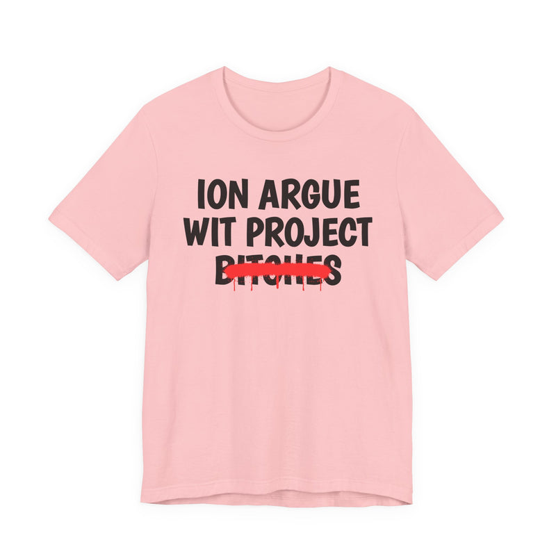 Pink t-shirt with black stacked uppercase "ION ARGUE WIT PROJECT BITCHES" lettering, "BITCHES" crossed by a red spray-paint strike with drips, front flat-lay view.