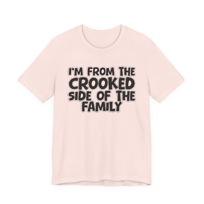 Soft Pink t-shirt, printed with the "I'M FROM THE CROOKED SIDE OF THE FAMILY" statement in bold outlined bubble lettering, front flat-lay view.