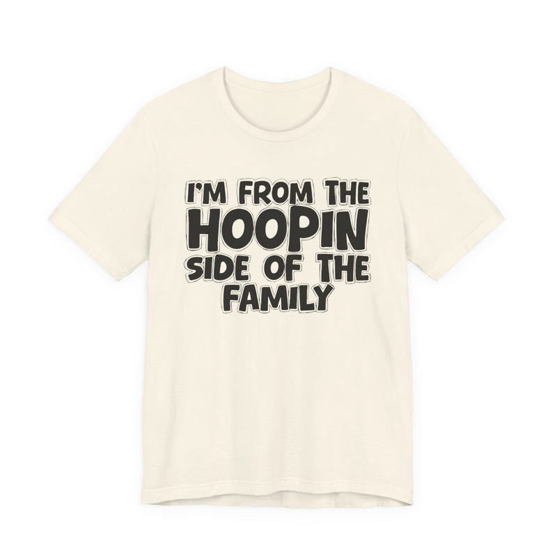 Natural t-shirt with white outlined bubble lettering reading 'I'M FROM THE HOOPIN SIDE OF THE FAMILY', front flat-lay view.