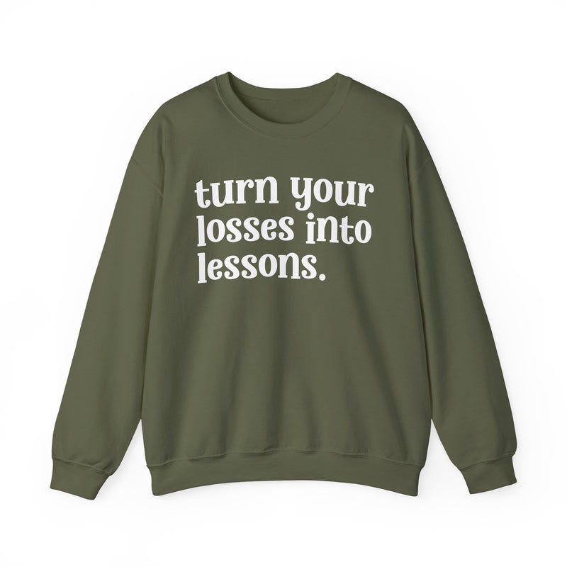 Military green crewneck sweatshirt with white "turn your losses into lessons." lettering, front view.