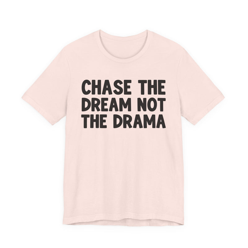 Natural t-shirt with black bold statement lettering reading CHASE THE DREAM NOT THE DRAMA, front flat-lay view.
