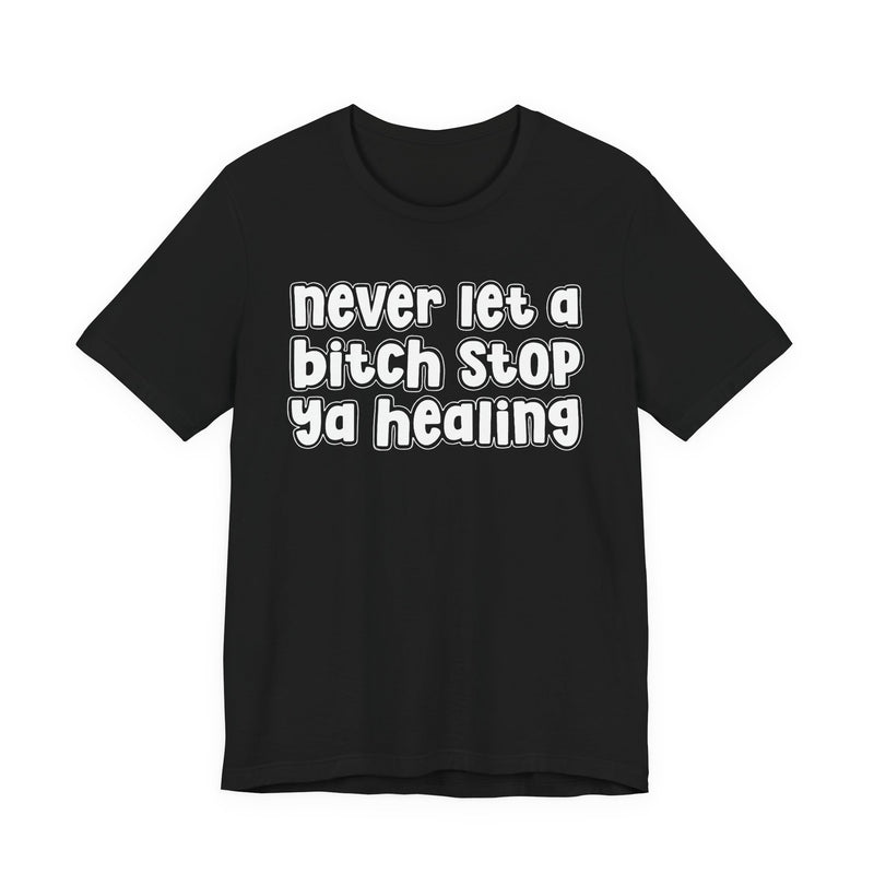 Graphic t-shirt with bold statement lettering reading "NEVER LET A BITCH STOP YA HEALING", front view, product mockup