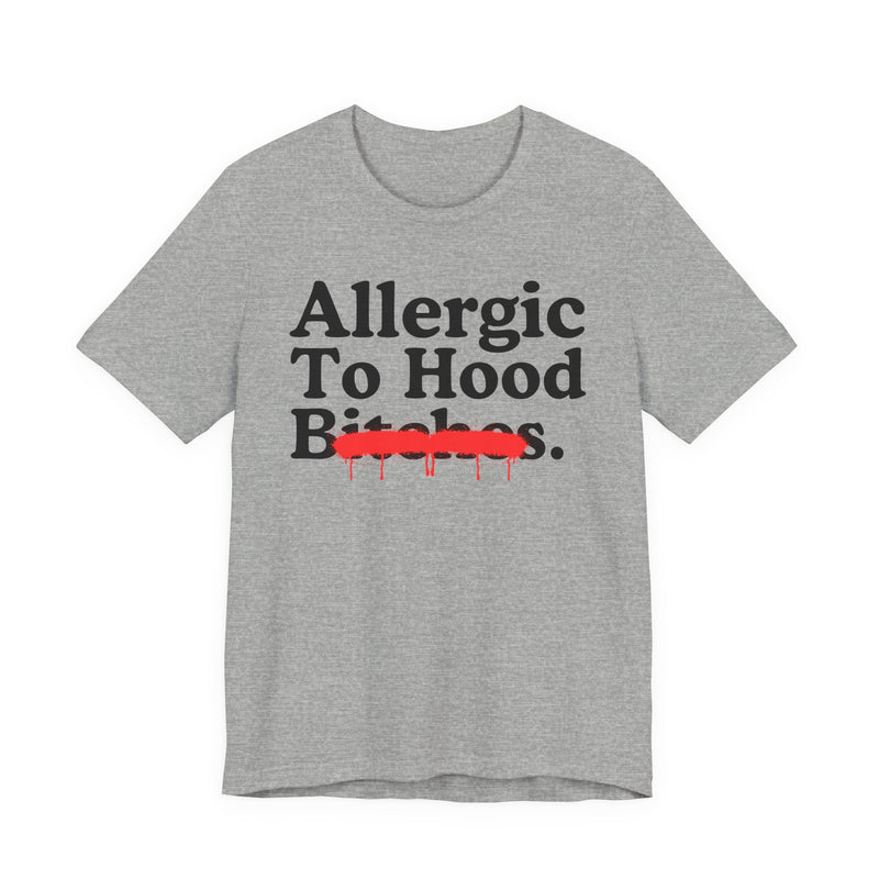 Athletic Heather T-Shirt with serif lettering reading Allergic To Hood Bitches, crossed by a red dripping strikethrough, front flat-lay view.
