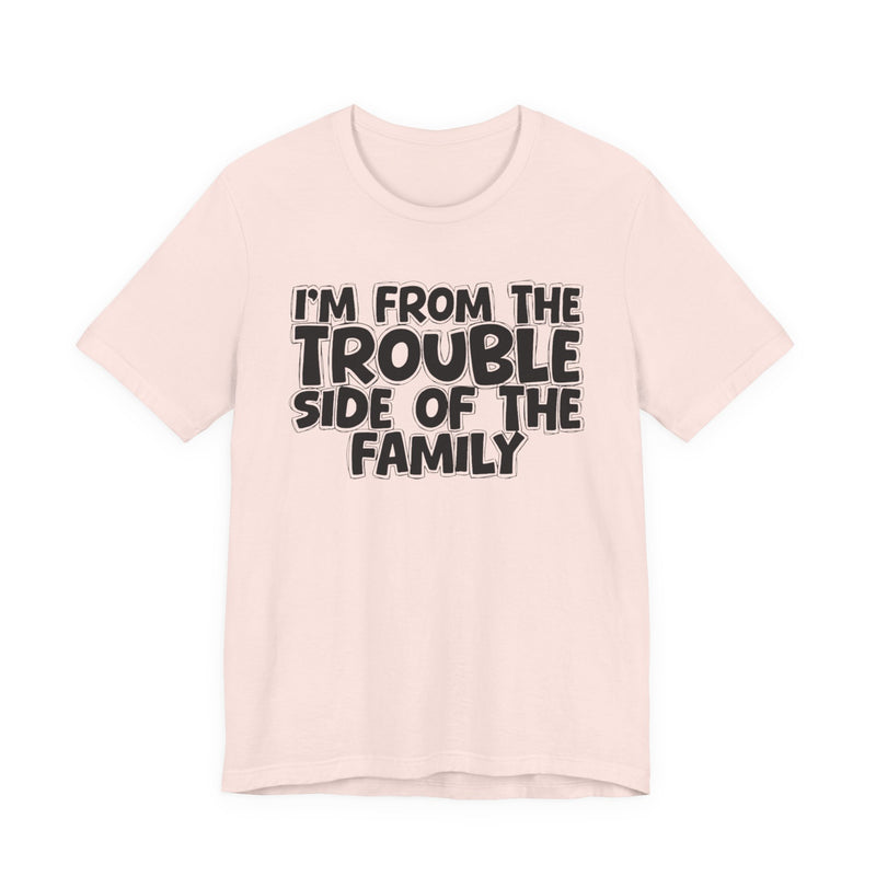 Soft Pink t-shirt, printed with the "I'M FROM THE TROUBLE SIDE OF THE FAMILY" statement in bold outlined bubble lettering, front flat-lay view.