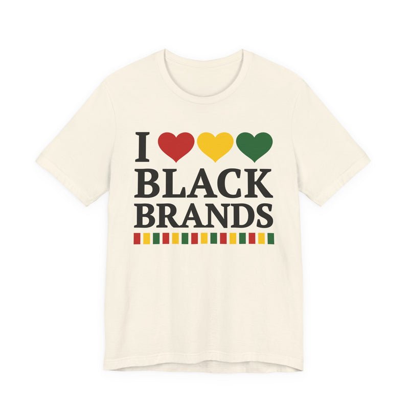 Front flat-lay of the I Love Black Brands t-shirt in Natural: black 'I' with red, gold, and green hearts above black 'BLACK BRANDS' collegiate lettering, with a red, gold, and green stripe bar beneath the text.