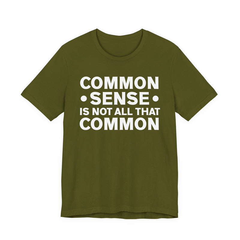 Charcoal t-shirt with sand collegiate lettering reading COMMON SENSE IS NOT ALL THAT COMMON, flat-lay view.