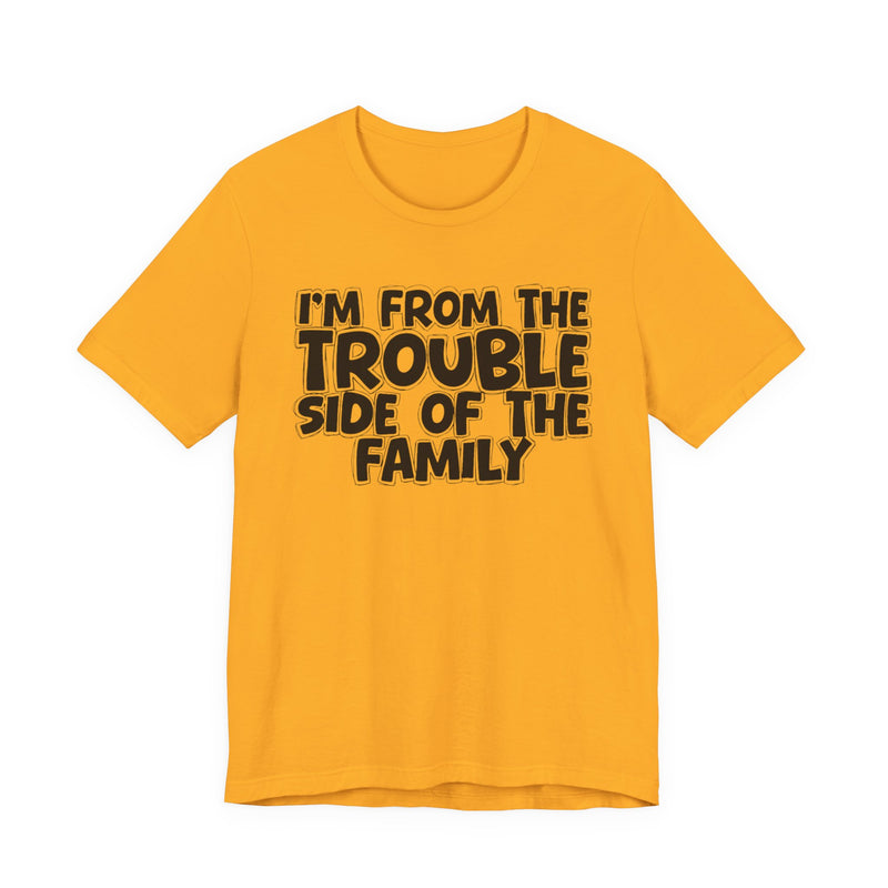 Gold t-shirt, printed with the "I'M FROM THE TROUBLE SIDE OF THE FAMILY" statement in bold outlined bubble lettering, front flat-lay view.