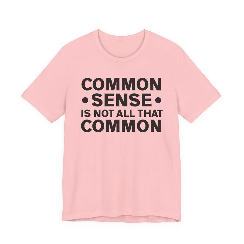 White t-shirt with milgreen collegiate lettering reading COMMON SENSE IS NOT ALL THAT COMMON, flat-lay view.