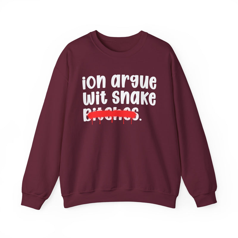 Maroon sweatshirt with white printed statement graphic, front view: 'ion argue' and 'Wit snake' in rounded chunky lowercase lettering over distressed 'Bitches.' crossed by a red spray-paint strike with paint drips.