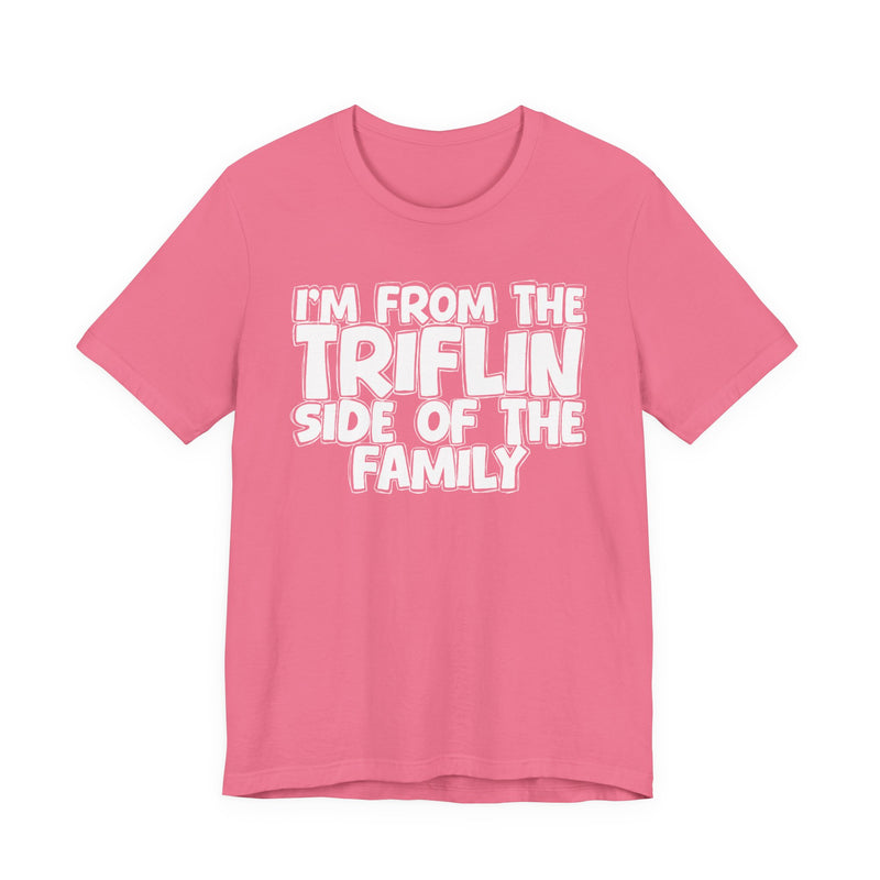 Pink t-shirt with "I'M FROM THE FAKE SIDE OF THE FAMILY" in bold black outlined bubble lettering, front flat-lay view