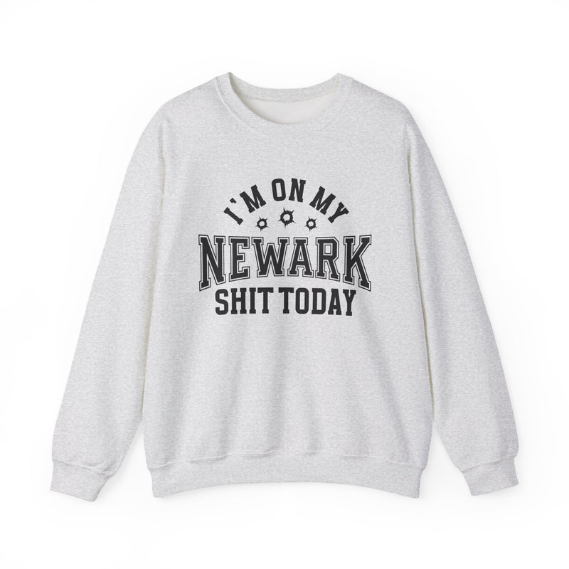 Sweatshirt product with collegiate lettering with bullet-hole accents reading I'M ON MY NEWARK SHIT TODAY, flat lay.