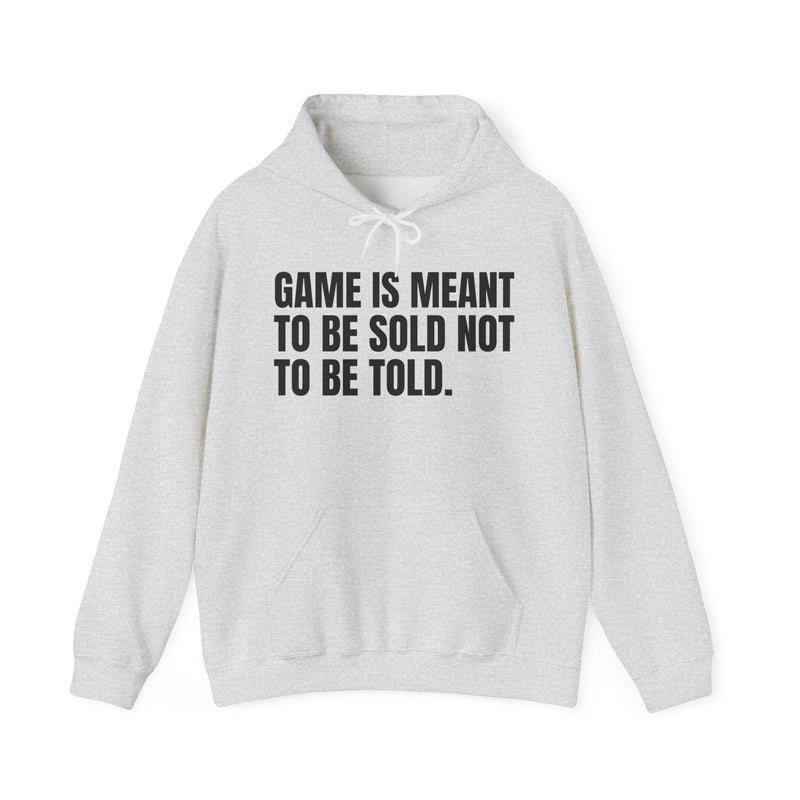 Light Pink hoodie with black condensed block lettering reading "GAME IS MEANT TO BE SOLD NOT TO BE TOLD.", front flat-lay view.