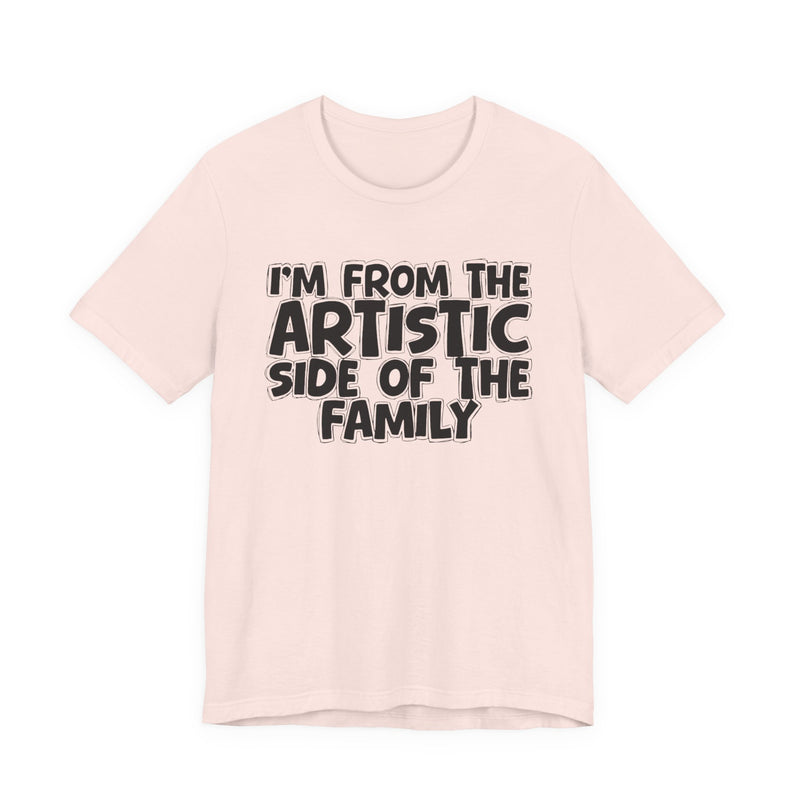 Olive t-shirt with bold chest statement text reading 'I'M FROM THE ARTISTIC SIDE OF THE FAMILY,' front flat-lay view.