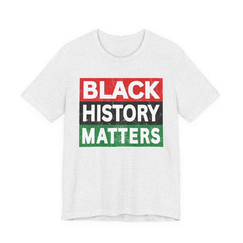 White t-shirt with ‘BLACK HISTORY MATTERS’ in block letters on red, black and green bars graphic in dark-contrast print, front flat-lay mockup view