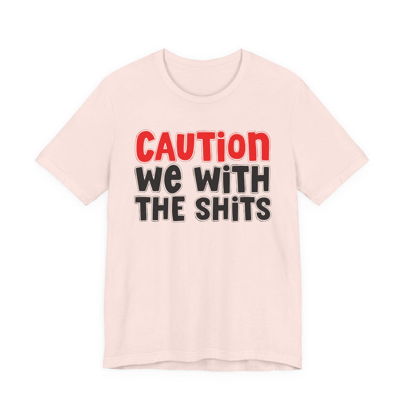 T-Shirt in Soft Pink with lettering reading "CAUTION WE WITH THE SHITS", front view.