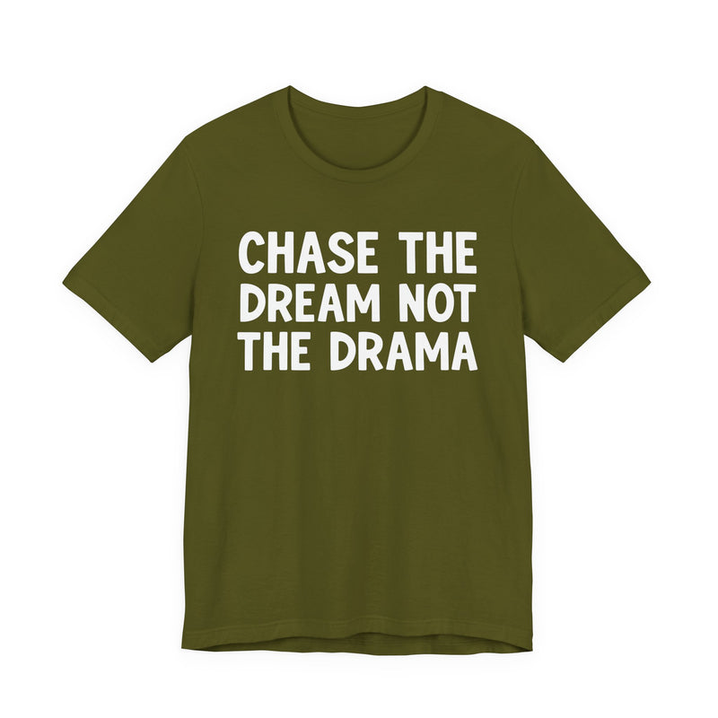 Gold t-shirt with white bold statement lettering reading CHASE THE DREAM NOT THE DRAMA, front flat-lay view.