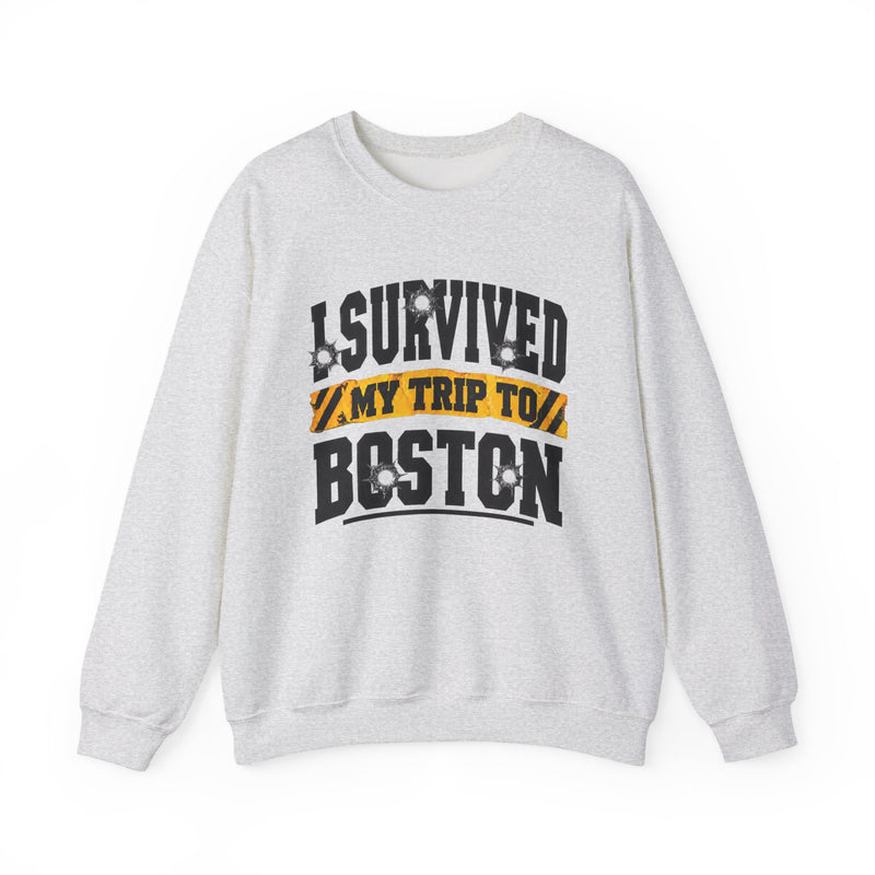 White sweatshirt with black block lettering reading I SURVIVED MY TRIP TO PHOENIX, with bullet-hole accents and a yellow caution-tape banner, front flat-lay view.