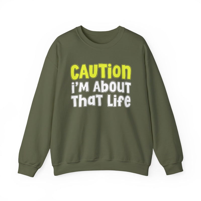 Sweatshirt in Military Green with lettering reading "CAUTION I'M ABOUT THAT LIFE", front view.