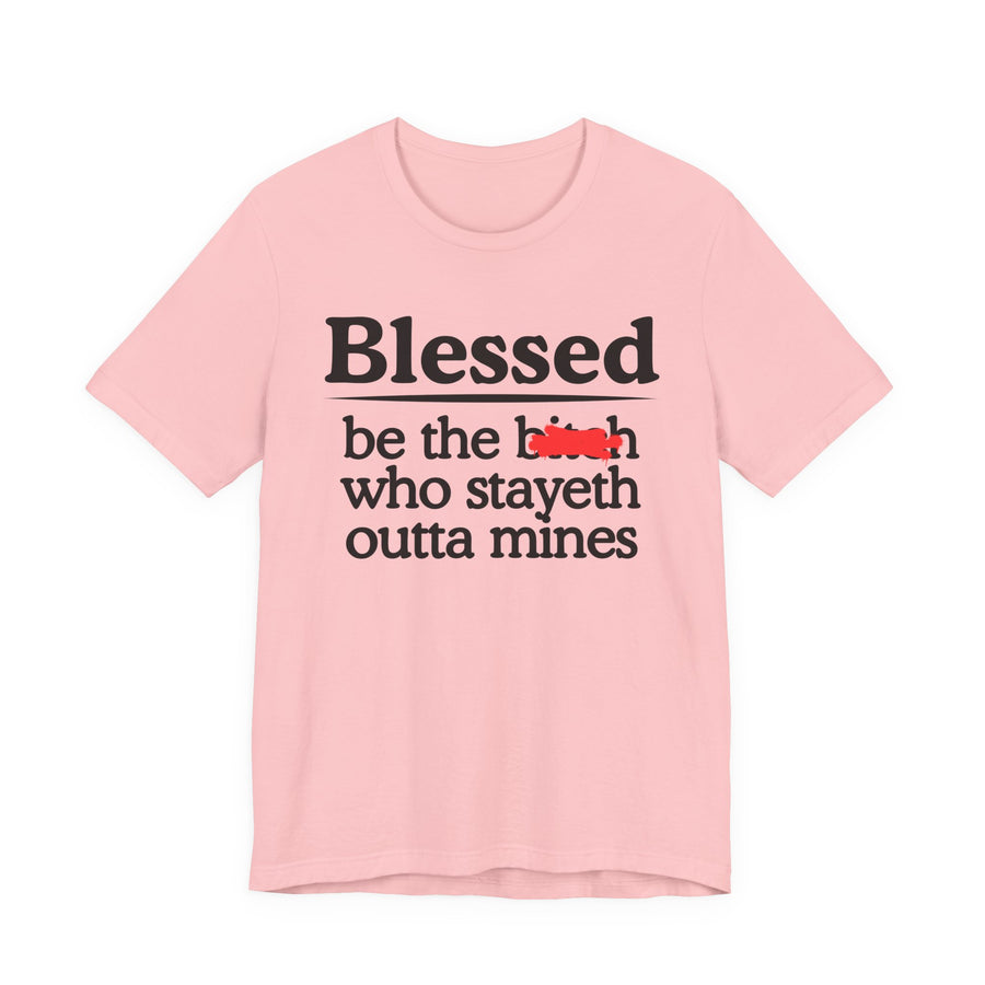 Charity Pink tee with black serif lettering reading "Blessed be the b—h who stayeth outta mines", front flat-lay view, with a red redaction mark over the middle word.