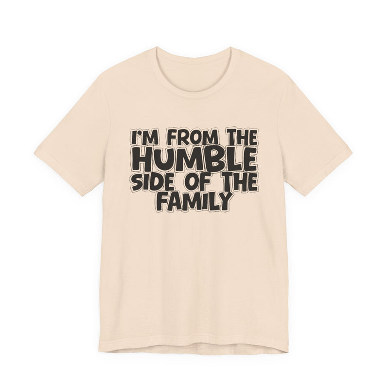 light t-shirt with ‘I’M FROM THE HUMBLE SIDE OF THE FAMILY’ statement text in bold outline lettering, front flat-lay view.