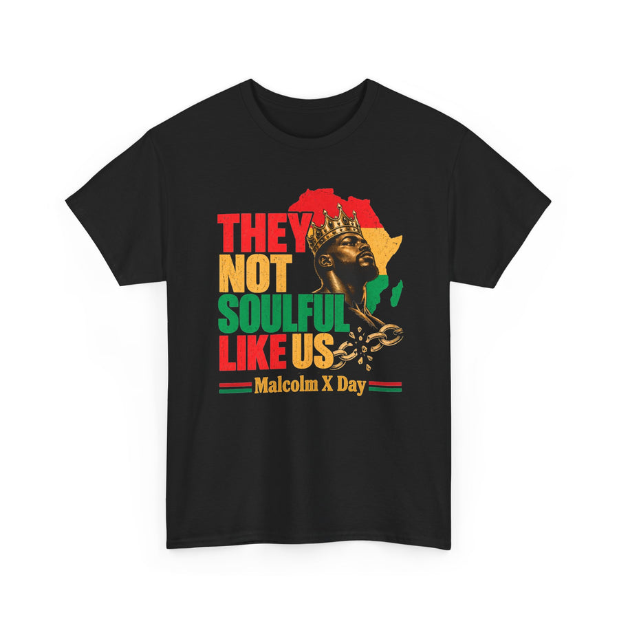 They Not Soulful Like Us Malcom X Birthday T-Shirt: black t-shirt front flat-lay with Pan-African red, gold and green lettering reading THEY NOT SOULFUL LIKE US above a Malcolm X Day ribbon, with a crowned king figure, Africa map, and broken chains.