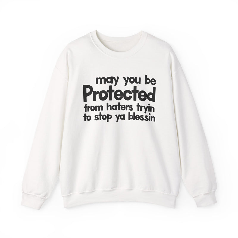 May You Be Protected From Haters Tryin To Stop Ya Blessin' — Sweatshirt fabric detail close-up: MAY YOU BE PROTECTED FROM HATERS TRYIN TO STOP YA BLESSIN' in bold statement lettering. Street Talk Designs protection statement apparel.