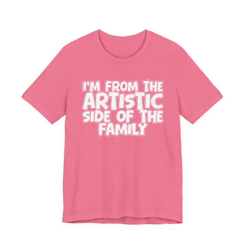 White t-shirt with bold chest statement text reading 'I'M FROM THE ARTISTIC SIDE OF THE FAMILY,' front flat-lay view.