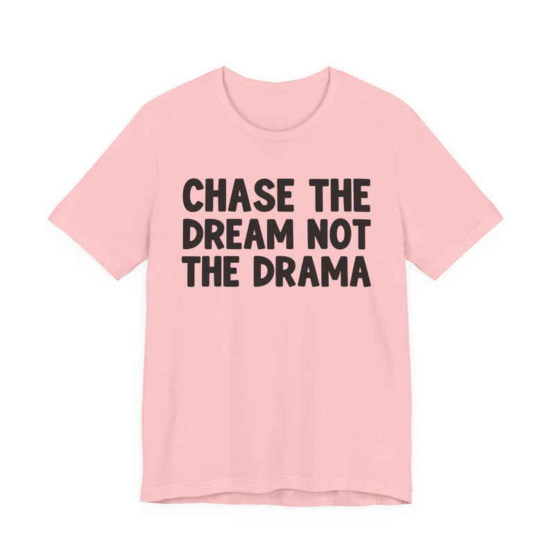 Natural t-shirt with black bold statement lettering reading CHASE THE DREAM NOT THE DRAMA, front flat-lay view.
